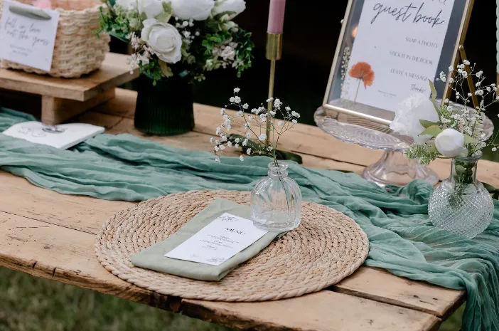 Outdoor wooden welcome table green cheesecloth runner