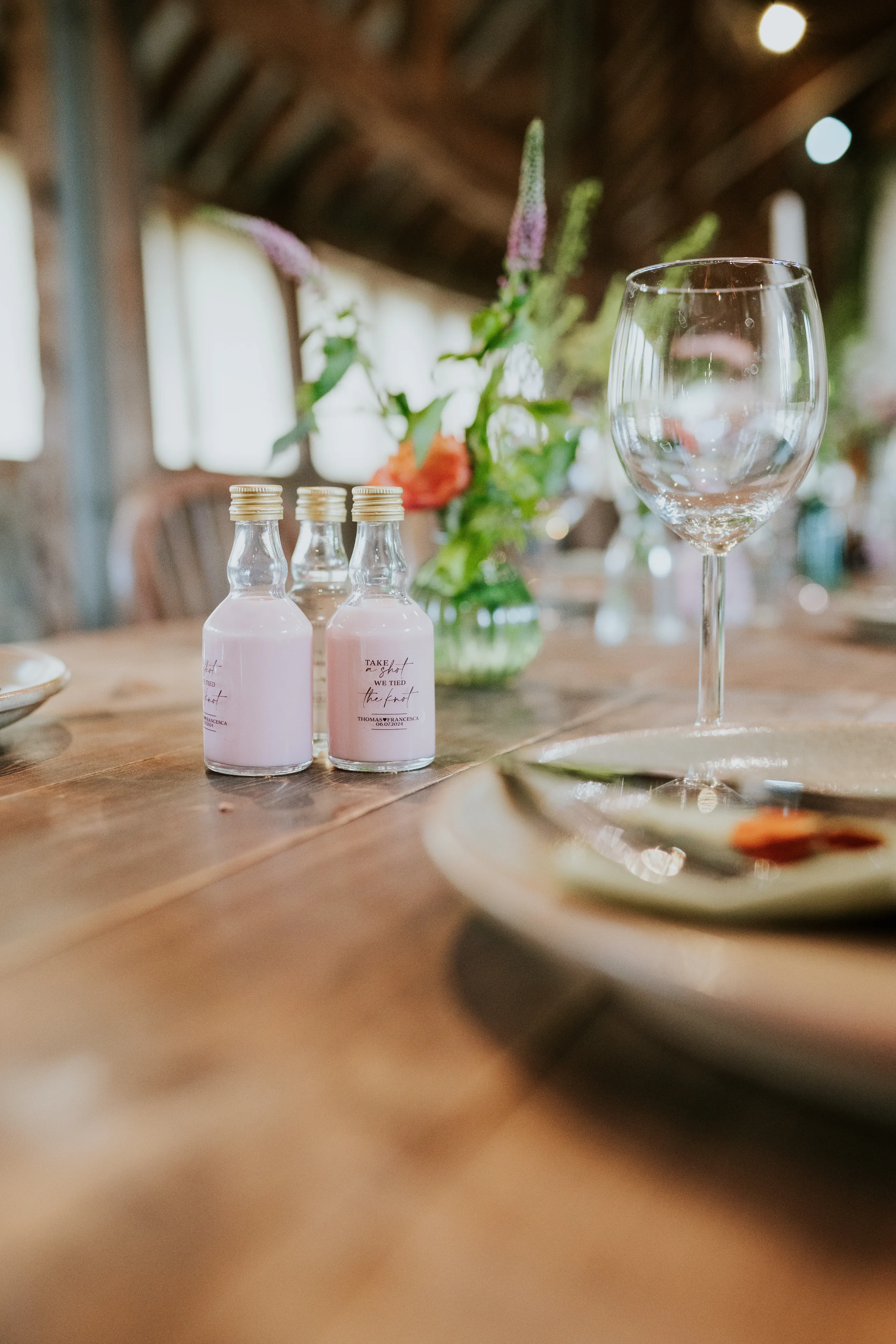 Wedding favor pink shot bottles rustic table